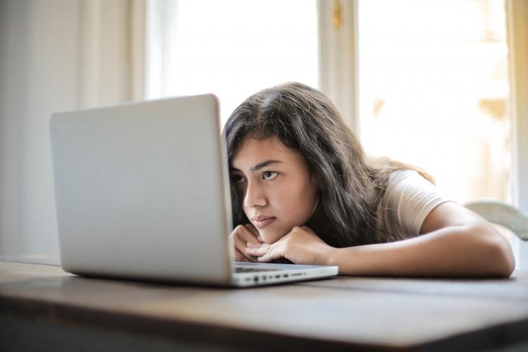 Eine Frau sitzt gelangweilt vor dem Computer