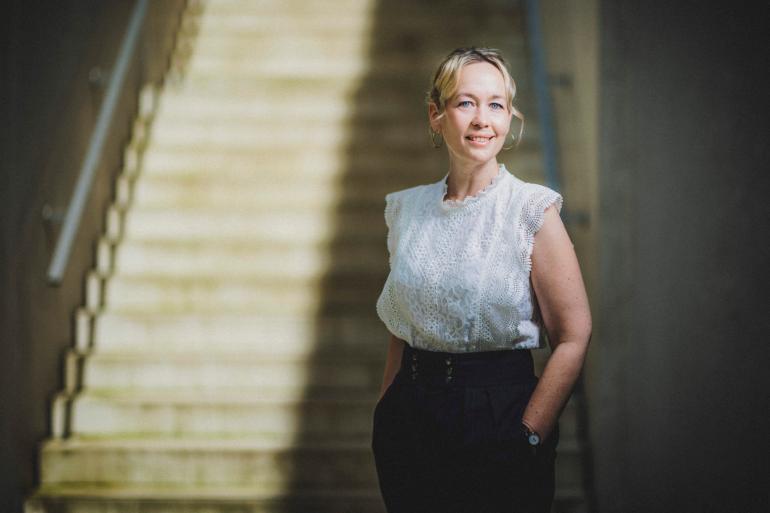 Foto: Stolenmoments photography Silke Rusch steht vor einer sonnenbeschienenen Treppe.