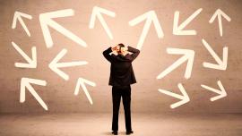 Ein Mann ist von hinten zu sehen vor einer Wand voller weißer Pfeile