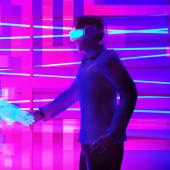 2 Personen mit VR-Brillen geben sich in einer virtuellen Welt die Hand.