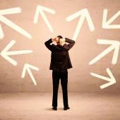 Ein Mann ist von hinten zu sehen vor einer Wand voller weißer Pfeile