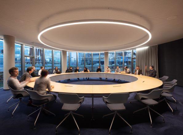 Konferenzraum der GIZ, in der Mitte ein großer Tisch, um den herum Menschen sitzen.