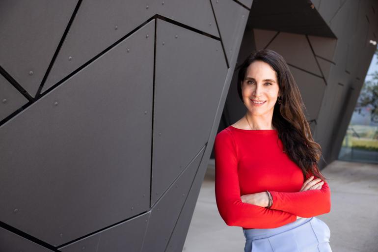 Die Zukunftsforscherin Anabel Ternès lehnt an einem futuristisch gemusterten grauen Gebäude.