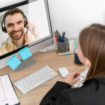 Eine Frau unterhält sich per Videotelefonie mit einem Mann am PC.