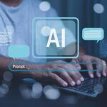 Man sieht die Hände einer Person auf einer Tastatur, in der Mitte stehen "AI" und "Prompt: ____"