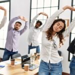 5 Arbeitnehmende stretchen sich im Büro