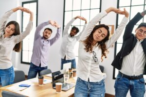 5 Arbeitnehmende stretchen sich im Büro
