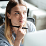 Nahaufnahme einer nachdenkenden jungen Frau am PC